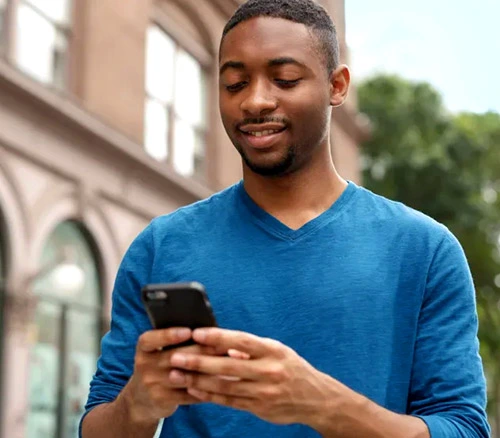 Man texting while walking outside
