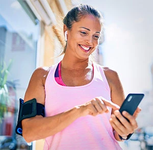 Older woman starting workout outside using phone