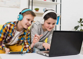 Boys playing game on phone and laptop